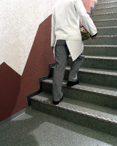 Man walking up stairs with dish on flooring system