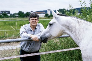 Eco friendly flooring image depicts horse with owner standing near farm fence.
