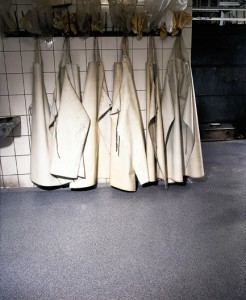 Work aprons rest in wait above freezer room floor.