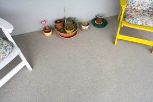 Potted plants rest outside atop a concrete floor system that looks like natural rock.