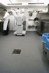 A working restaurant kitchen bustles with life over a newly installed seamless flooring system.