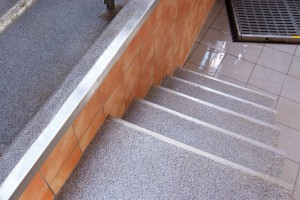 Stairs lead to a poured deck flooring system both displaying a beautiful grey white floor design.