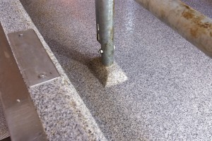 Close up view of a metal deck support surrounded by a poured deck flooring system.