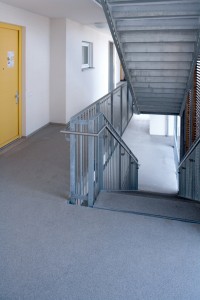 A new hallway floor covering system wraps around an interior flight of steps leading both up and down.