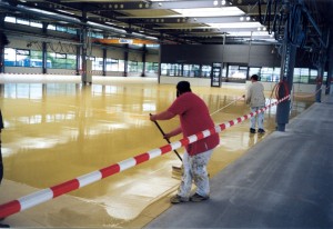 A floor coating system supplier helps his contractor install a poured floor system in a large warehouse facility.