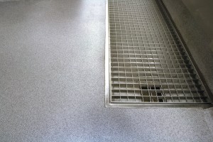 An institution flooring finish seamlessly surrounds this large floor drain.