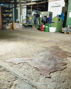 A badly damaged concrete floor is swept prior to the first coating of self leveling floor resin.