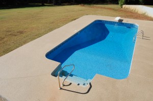 A pool deck cement coating around a pool protects against the elements.