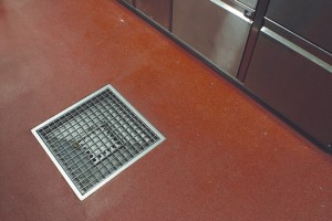 Flooring drains for sanitation protect this kitchen surface from any design of harm that may come from standing water, or spilled product.