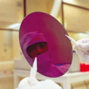 A scientist holds up an epoxy floor coating sample made chemical resistant.