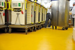 Bright mustard yellow colored concrete floor system supports commercial rolling buggies.