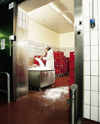 Man shoveling ice inside a walk in freezer floor that was recently repaired