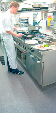 Chef Standing On Durable Flooring While Cooking In A Restaurant.