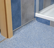 Shower entry flooring protected by an impregnated acrylic system.