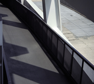 Exterior airport gateway casts shadows across seamless grey acrylic flooring system.