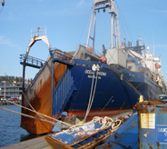 Large cargo boat loads boat floor covering supplies.