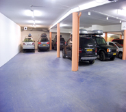Garage parking deck displays durability in flooring system as numerous cars show parked.