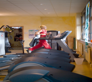 Woman jogs on treadmill that sits atop a fitness center floor.