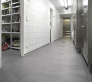 Silver grey floor system projects stellar seamless quality for commercial kitchen area.