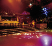 Dance floor of night club chose bright red acrylic coating option that is able to reflect multi colored light show atop surface.