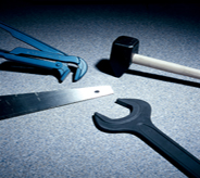 Several hand tools lie atop a blue grey hangared flooring system.