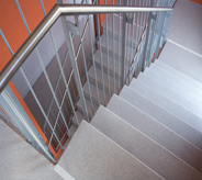 Stair lines with grey floor leading to motel rooms from lobby.