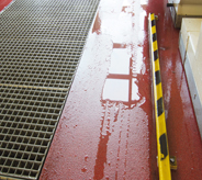 Outdoor waterproof flooring shows surface top moisture beading atop red colored car wash floor coating.
