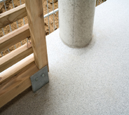 Grey seamless flooring surrounds wood rail and wide column with outdoor waterproofed protection.