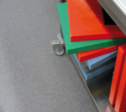 Brightly colored pharmaceutical carts stacked on grey floor.