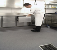 Chef preps in kitchen with slip resistant floor.
