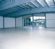 A bright white floor accents the open space in this large warehouse.