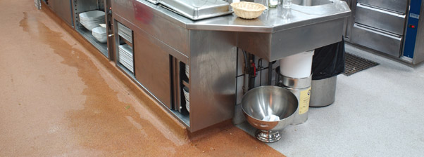 Massachusetts contractor provides commercial flooring for this large kitchen facility depicting residual water after recent mopping.