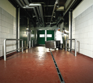 Worker moves large cart over sealed acrylic flooring.