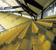 Yellow auditorium seating chairs rest atop grey flooring system.