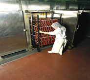 Man pushes cart across containment are floor.