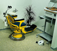 Dental chair on green flooring.