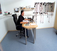 Employee sits at desk surrounded by bright blue office flooring.