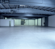 Wide view of empty hangar depicting soothing grey flooring coat.