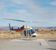 Helicopter lands on pad surrounded by poured floor.