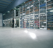Grey sealed concretes glimmer in light inside industrialized warehouse.