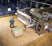 Resin coated industrialized concrete flooring protects against skid and scuff as worker moves material with pallet jack.