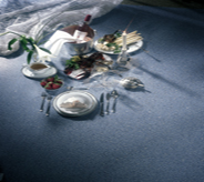 China and silverware cast shadows across dark interior sealed cocnretes.