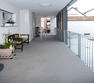 Motel walkway is lined with concrete floor.