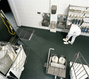 Nuclear facility worker wipes up slip off of floor with a cloth.