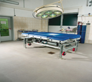 Surgeons table awaits patient atop grey colored operation room flooring system.