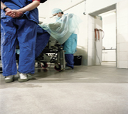 Surgeon meticulously attends patient atop operating room floor design.
