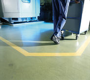 Man moves cart across floor in pharmaceutical room.