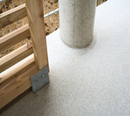 A column is surrounded by a poured floor on a pool deck.