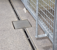 Prisoned floor system demonstrates seamless quality with intricate french drain near gated entryway.