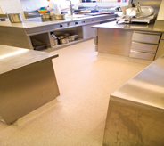 Peach colored kitchen flooring glimmers in resilient lighting from dining area.